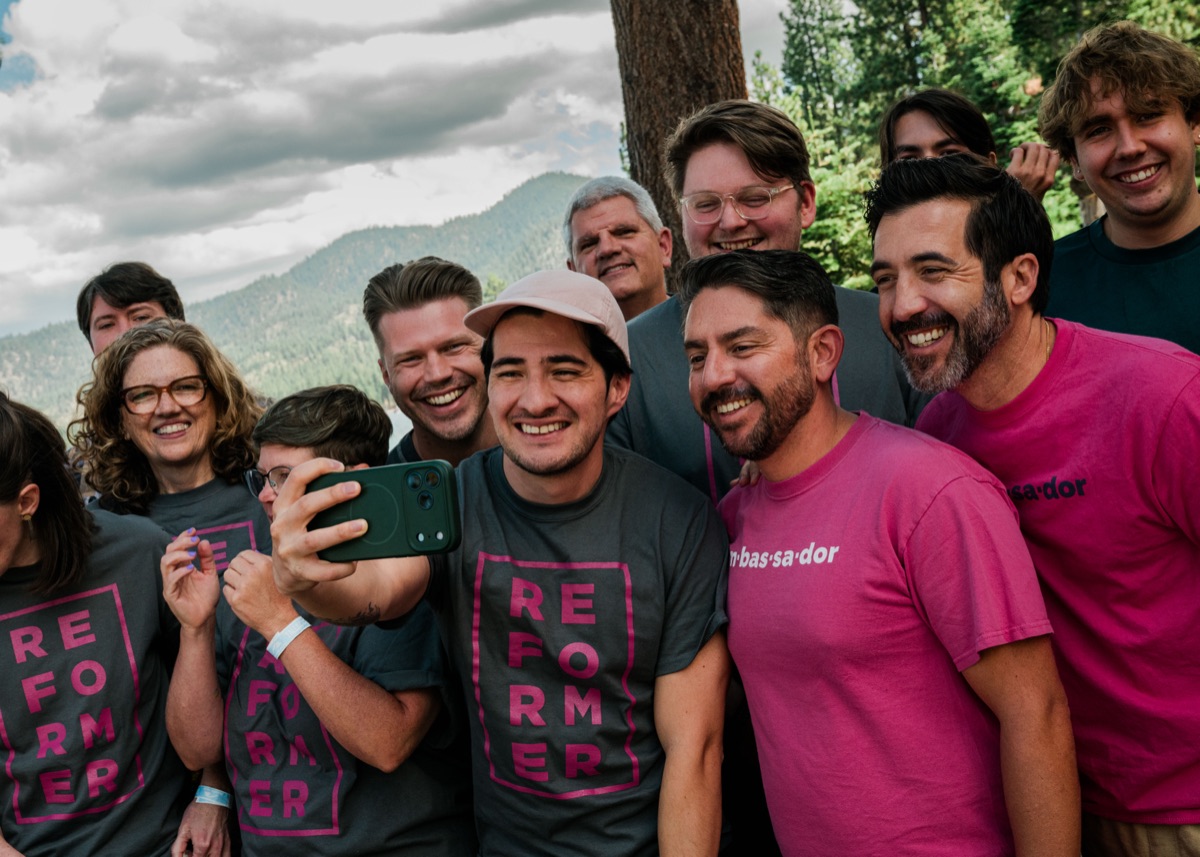 Cohort graduates in Reformer and ambassador shirts smiling for a group selfie