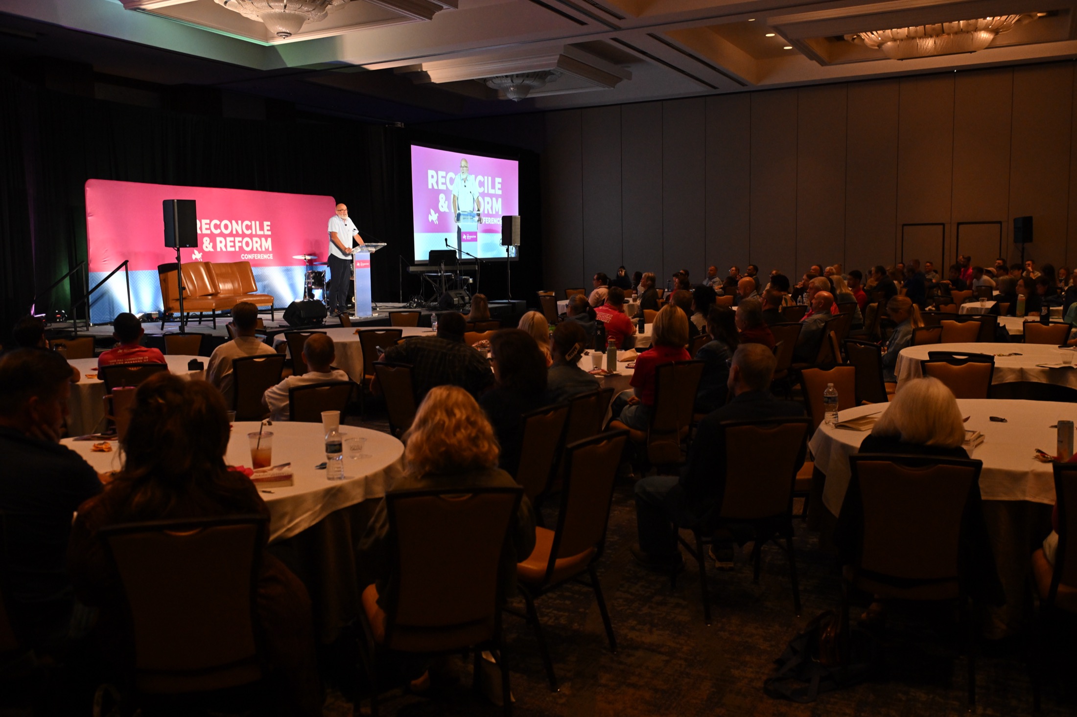 Attendees at round tables listening to a session at the 2025 Reconcile and Reform Conference